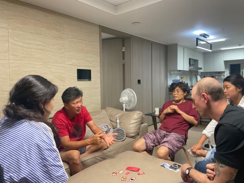 Patrick and Courtney sitting on a couch with relatives playing go-stop