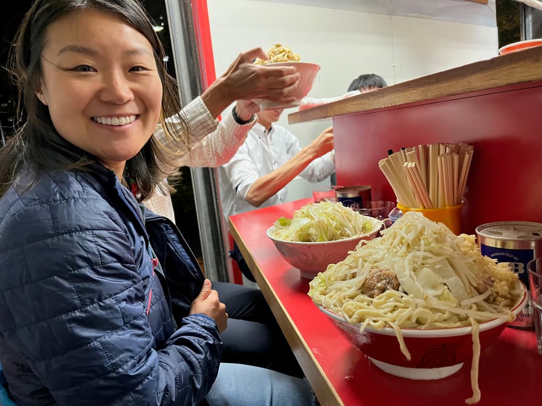 Courtney in front of two heaping bowls of ramen